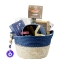 Full view of The Aegean Blue Collection gourmet gift basket by Elenianna, featuring a blue wicker hamper with an evil eye charm, filled with Kyklopas olive oil, Cretan pasta, organic figs, and sea salt on a white background.