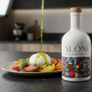 ALÓNI 'The Grove' Limited Edition EVOO bottle with collectible art by Greek artist Soteur shown next to its matching gift box